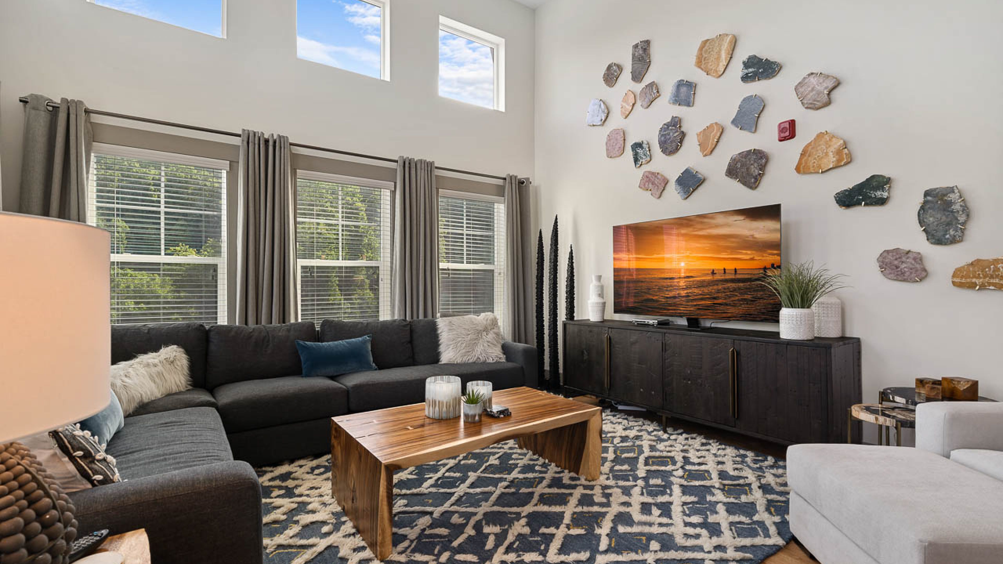 Hawthorne at Mills Gap apartment living room with large windows, furnished with a couch, coffee table, and chair