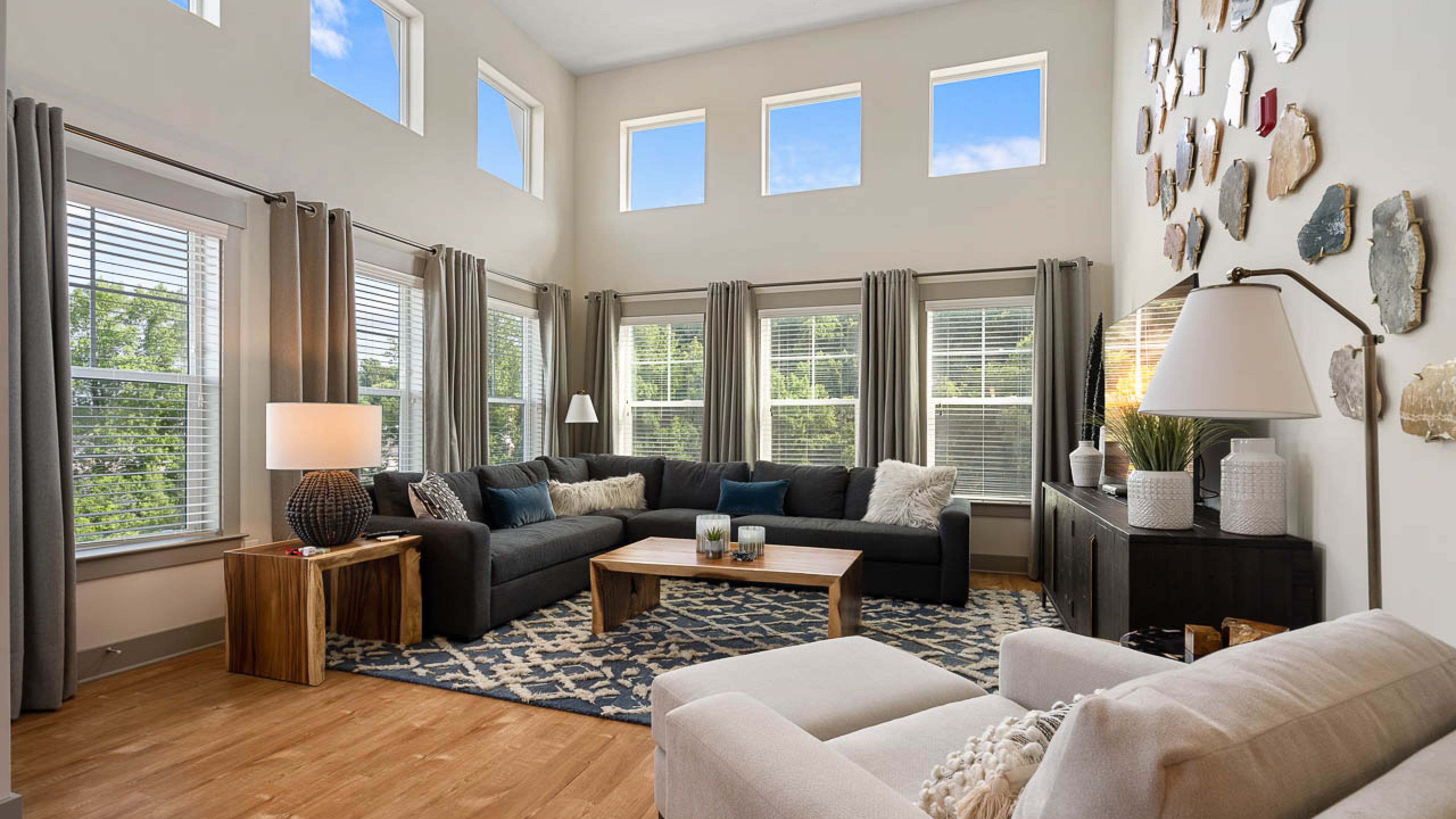 Hawthorne at Mills Gap spacious apartment living room with high ceilings and large windows, furnished with a couch, coffee table, and chair